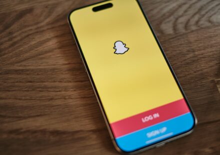 A yellow and blue iPhone sitting on top of a wooden table