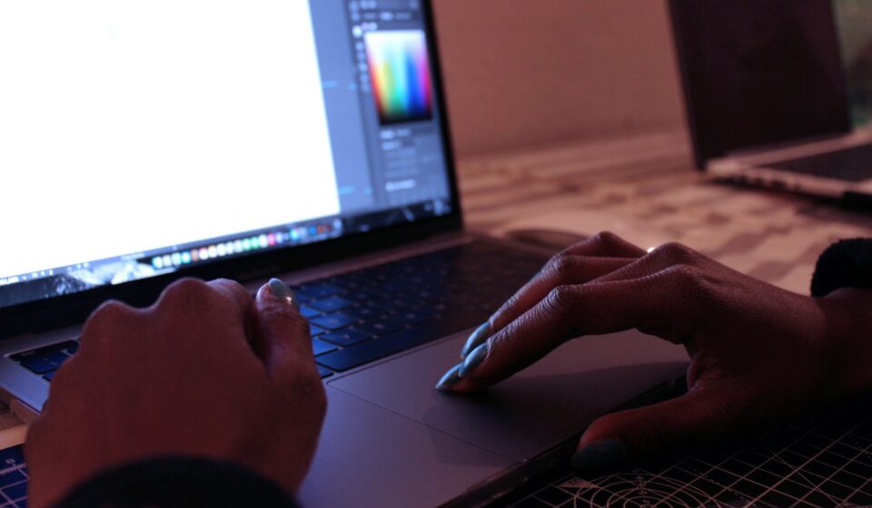 person using macbook pro on brown wooden table
