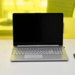 Sleek laptop with a blank screen and wireless mouse on a white desk.