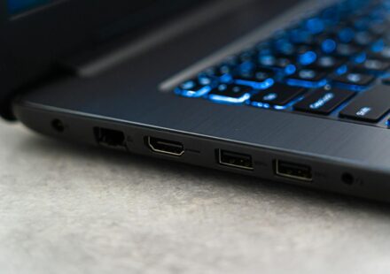 Detailed close-up of a laptop featuring backlit keyboard and various ports highlighting modern technology.