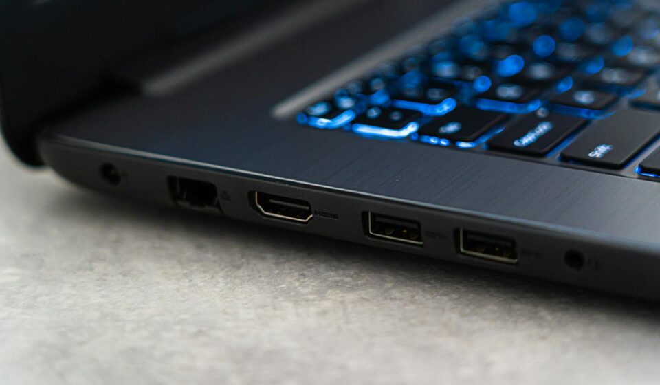 Detailed close-up of a laptop featuring backlit keyboard and various ports highlighting modern technology.