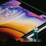 man in white shirt and blue denim jeans standing on blue and yellow water