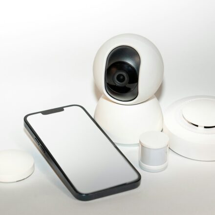 a smart phone sitting next to a security camera