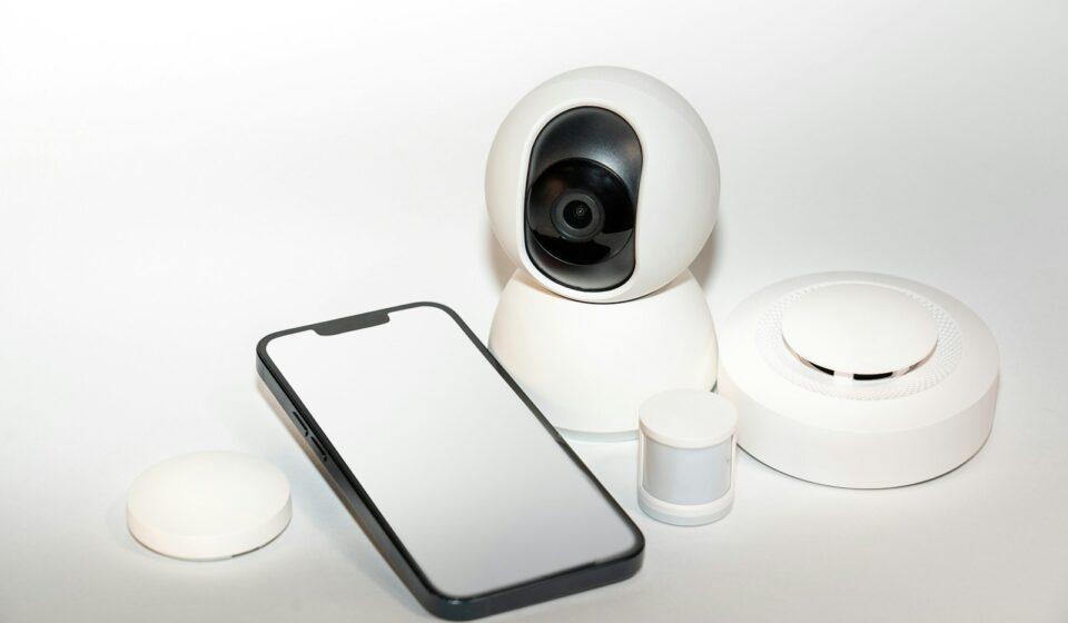 a smart phone sitting next to a security camera