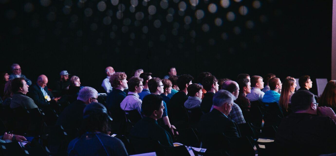 crowd of people sitting on chairs inside room