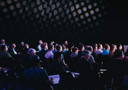 crowd of people sitting on chairs inside room