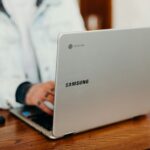 shallow focus photography of person using gray Samsung laptop