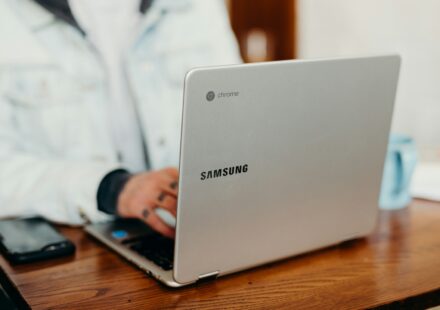 shallow focus photography of person using gray Samsung laptop