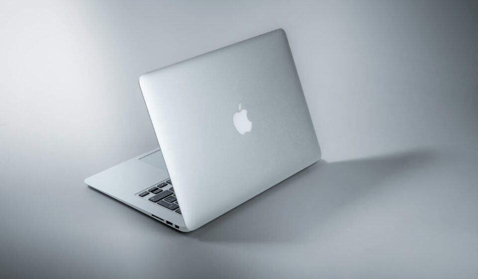 silver macbook on white table