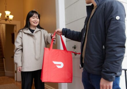 a woman holding a red bag standing next to a man
