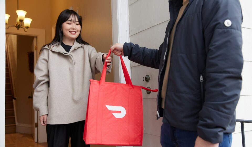 a woman holding a red bag standing next to a man