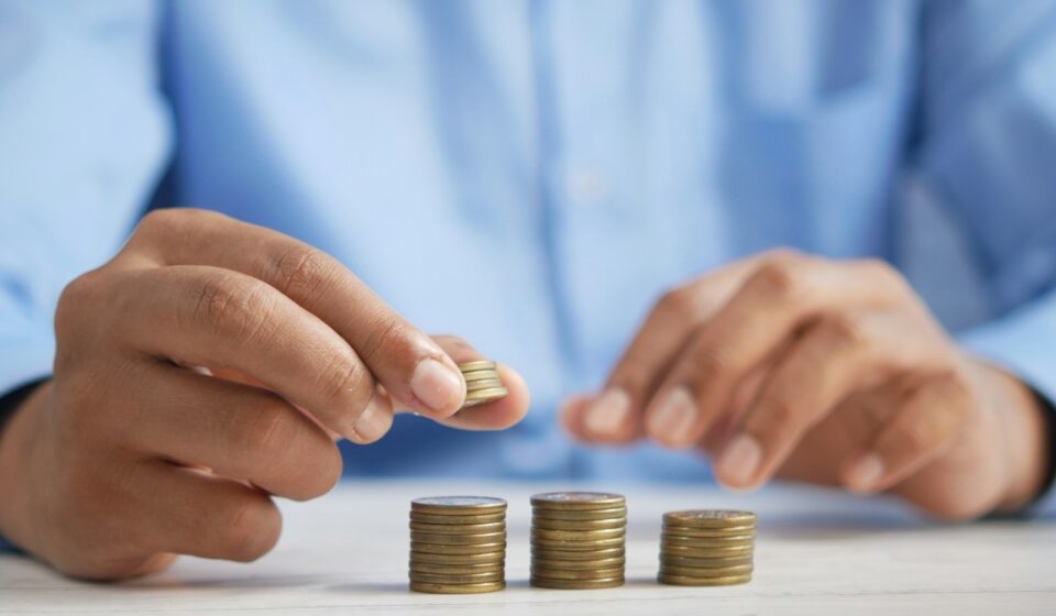 a person stacking coins on top of a table