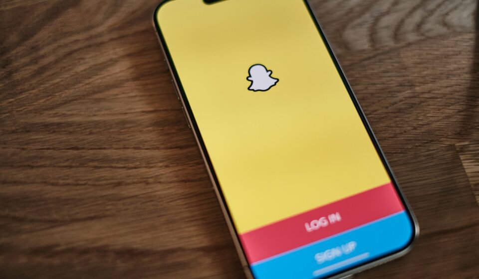 A yellow and blue iPhone sitting on top of a wooden table