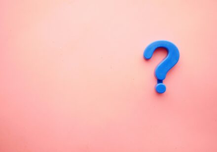 a blue question mark on a pink background