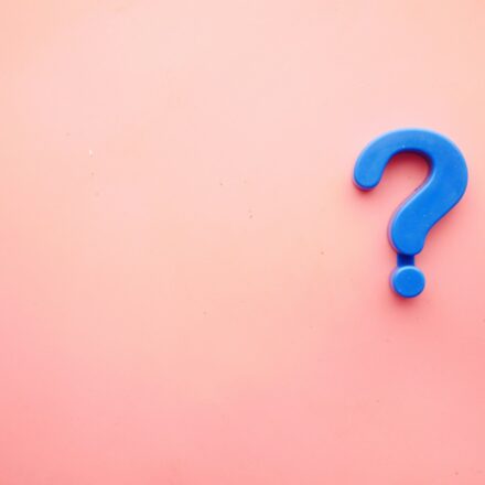 a blue question mark on a pink background