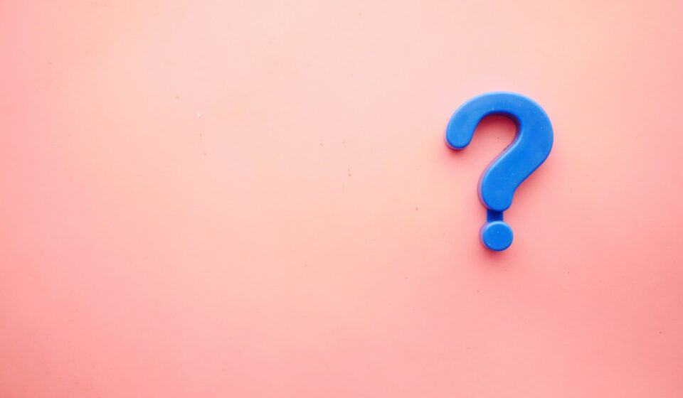 a blue question mark on a pink background