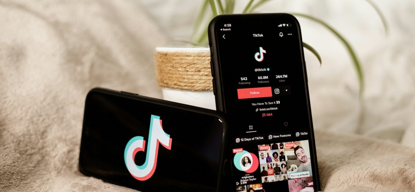 a couple of cell phones sitting on top of a bed