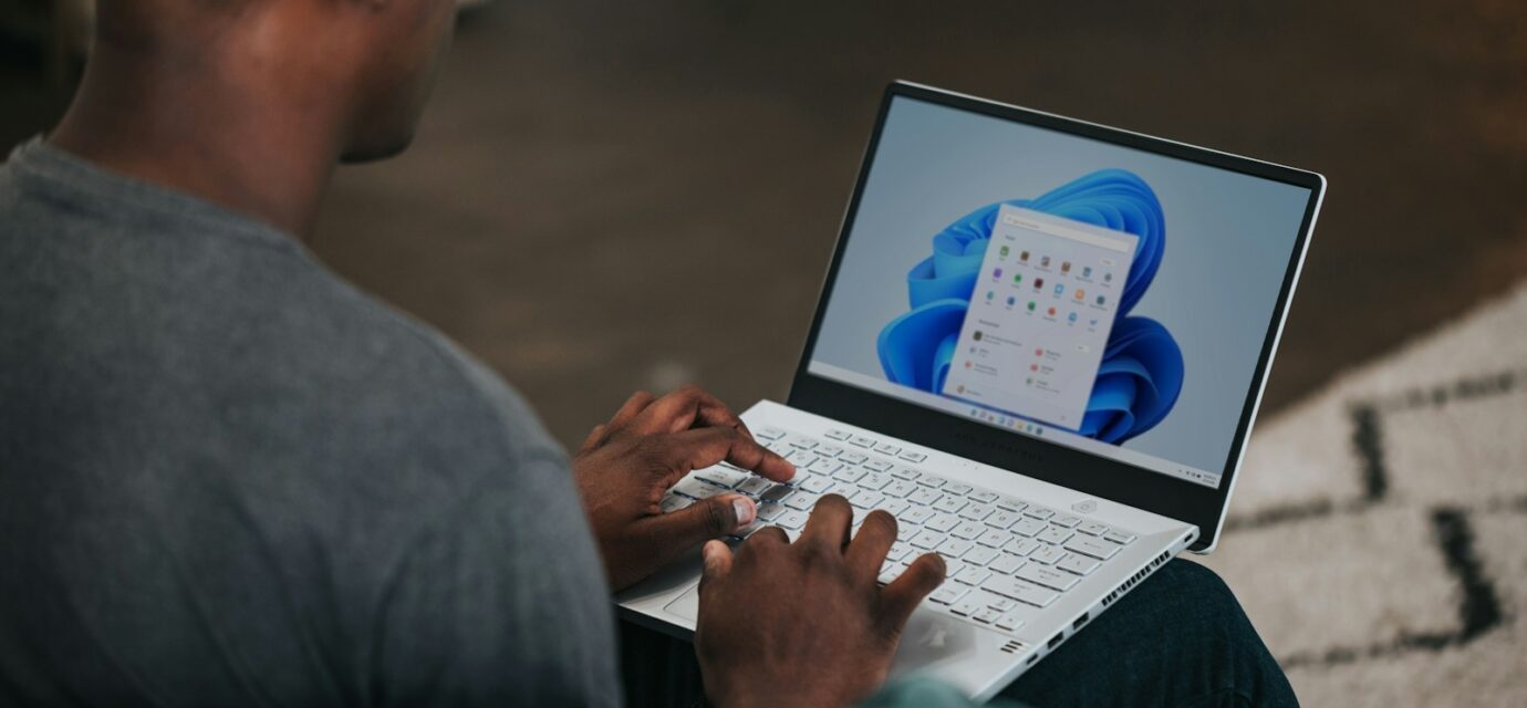 man in gray long sleeve shirt using Windows 11 computer