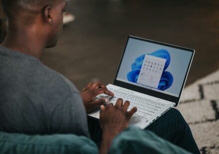 man in gray long sleeve shirt using Windows 11 computer