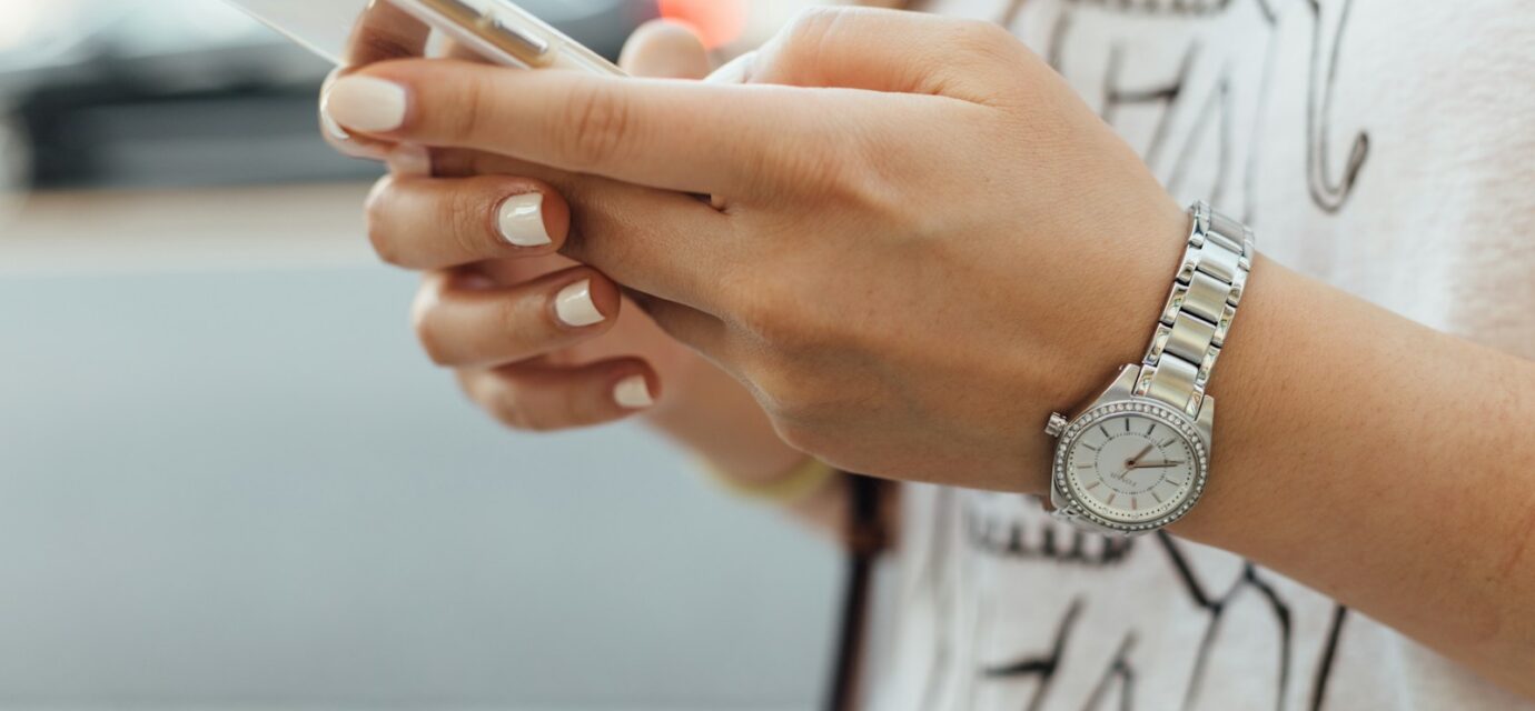 woman holding iPhone during daytime