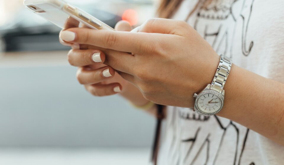 woman holding iPhone during daytime