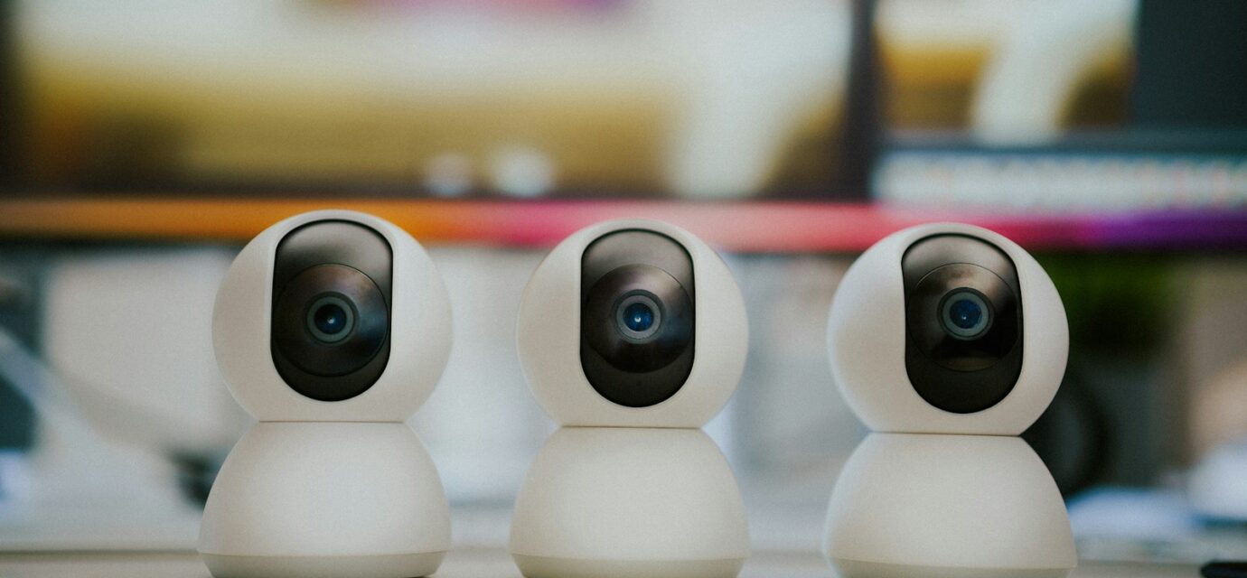 Three small white cameras sitting on top of a table