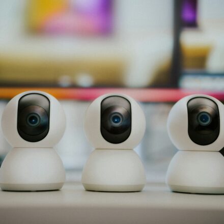 Three small white cameras sitting on top of a table
