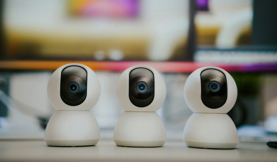Three small white cameras sitting on top of a table