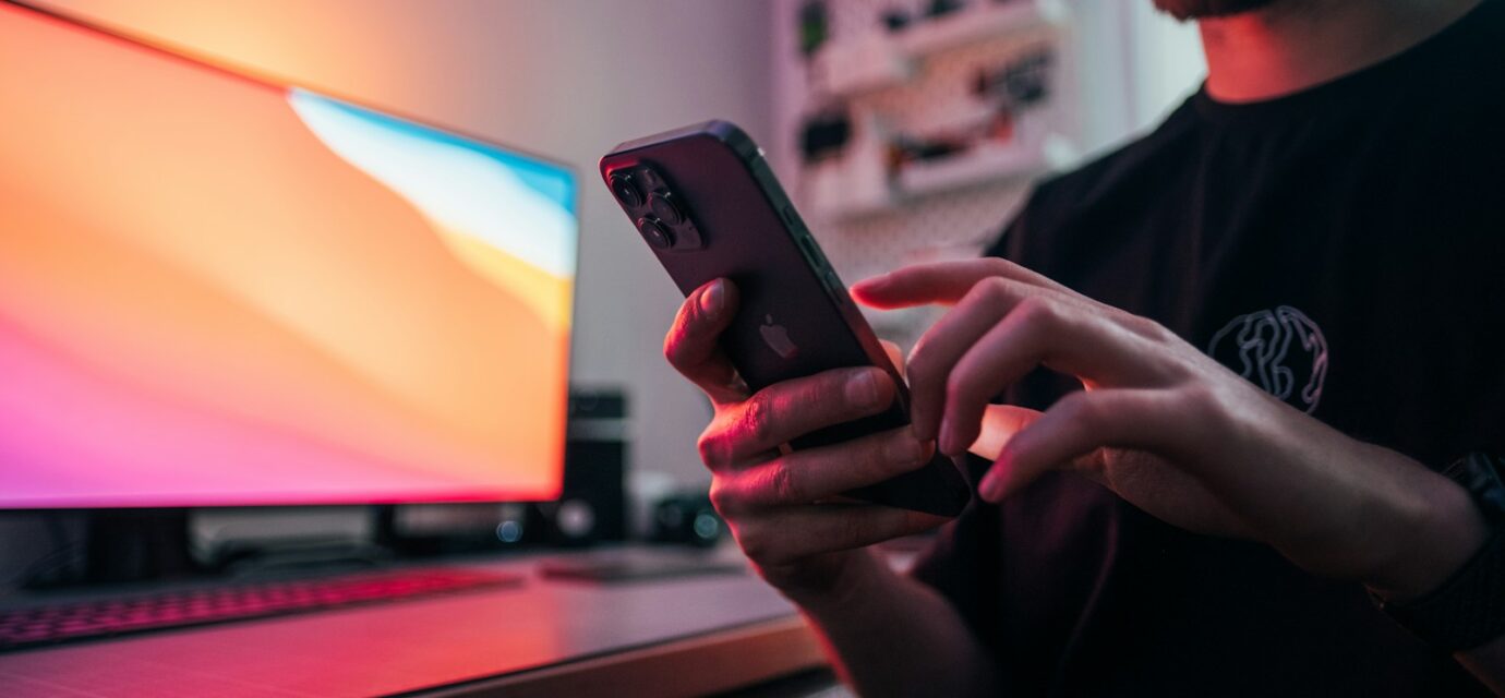 man in black shirt holding black iphone 5