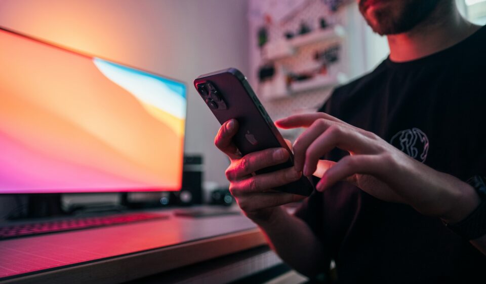 man in black shirt holding black iphone 5